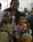 Adult with children holding drums. 