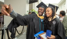 two new graduates taking a selfie. 