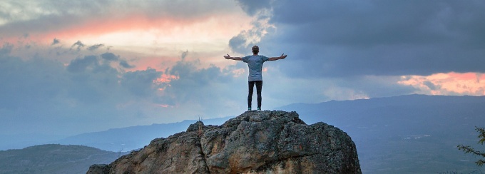 Person standing on mountain top. 