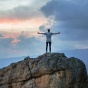 Person standing on mountain top. 