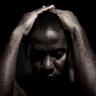 Black and white image - man with hands on head. 