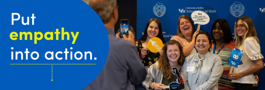 group of students at orientation holding up signs in a photobooth. 