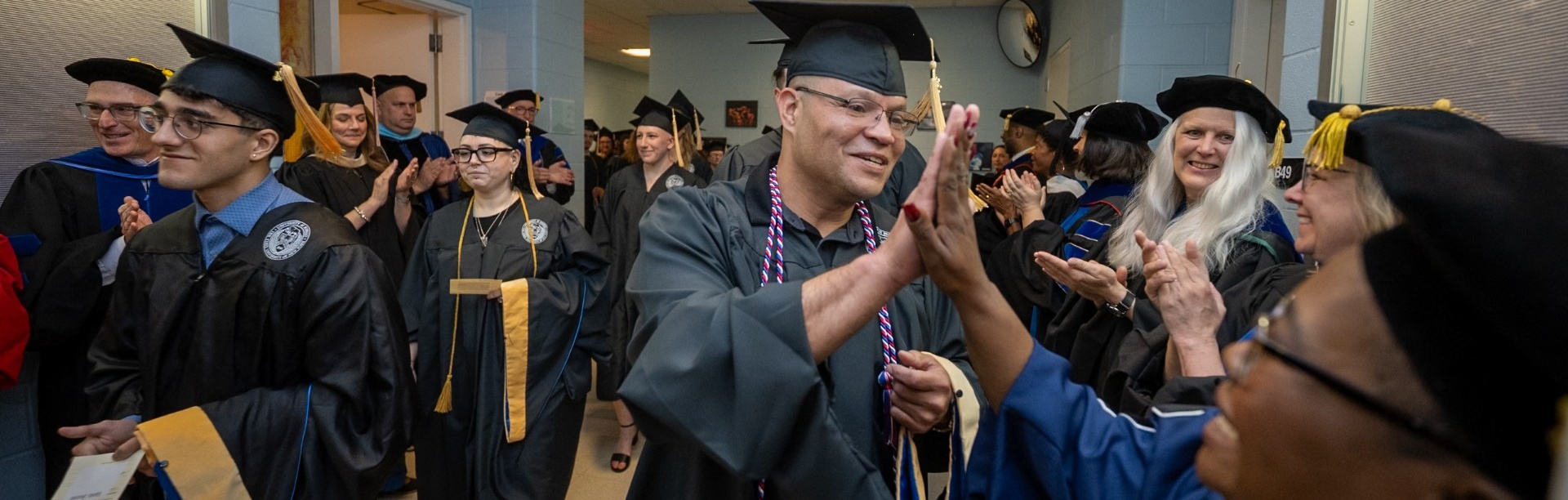 2025 MSW student highfiving a faculty member. 