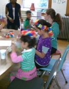 Children sitting at table working on crafts. 