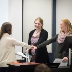 Three students with hands in for a group. 