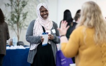 Zoom image: Student talking to agency staff at field fair. 