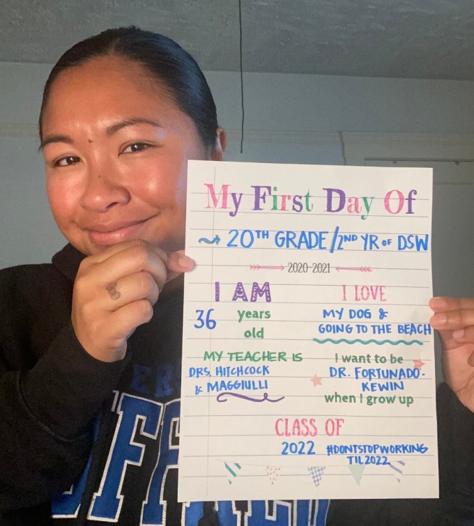 Michelle Fortunado-Kewin holding back-to-school sign that says "My first day of 20th grade, 2nd year of DSW. 2020-2021. I am 36 years old, my teacher is Drs. Hitchcock and Maggiulli. I love my dog and going to the beach. I want to be Dr. Fortunado-Kewin when I grow up. Class of 2022 #DontStopWorkingTil2022. 