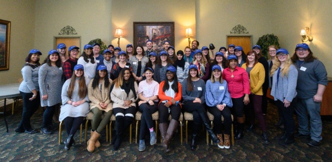 Zoom image: MSW students pose wearing blue UBSSW ballcaps at Challenge 2 Change event