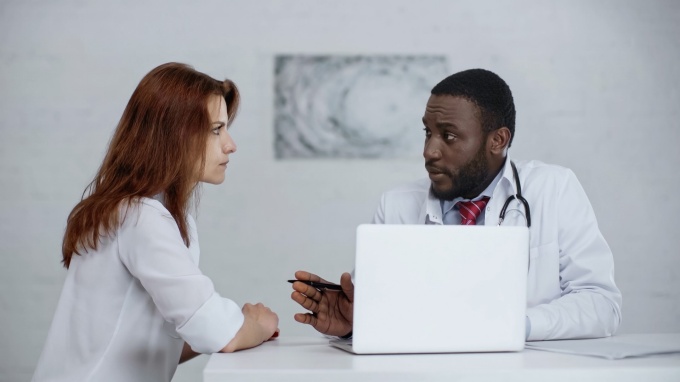 A doctor and patient having a conversation in office. 