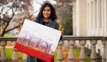 Shaanta Murshid holding large painting. 