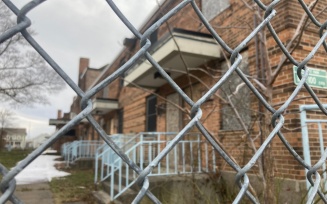 Zoom image: Housing project with boarded up windows.