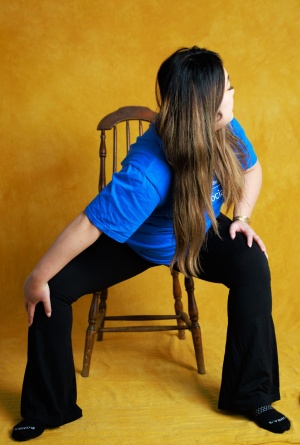 Tiffany Nhan in chair shoulder stretch pose. 
