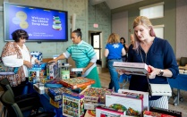 UB School of Social Work swap meet, people looking at and sharing items like puzzles and books.