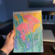 Rachel Remmes holding out a dot art book with a floral image. 