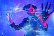 Person wearing a virtual reality headset and extending their arms with a galaxy overlay around them. 