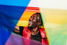 Man holding a price flag with outstretched arms and smiling with joy. 